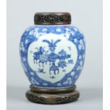 A Chinese Kangxi (1662-1722) blue and white ginger jar with pierced hardwood cover and stand.