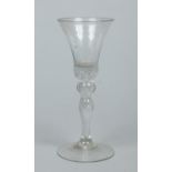 A Georgian wine glass with a bell shaped bowl raised on a knopped baluster airtwist stem c.