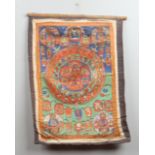 A 19th century Tibetan Thangka painted on textile to depict deities, 76cm x 60cm.