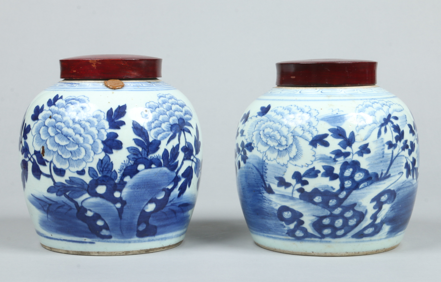 A pair of 18th century Chinese blue and white ginger jars with associated hardwood covers.