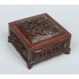 A 19th century Chinese carved and reticulated hardwood box of square form and with fitted internal