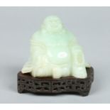 A boxed Chinese carved jadeite figure modelled as a seated hotei raised on a pierced hardwood