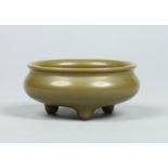 A Chinese earthenware censor of plain circular form and raised on three pointed feet.