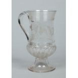 A George III large glass pedestal ale mug of waisted form and with scrolling handle.