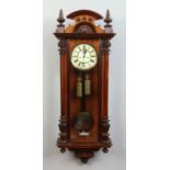 A 19th century carved walnut Vienna wall clock. With enamel dial incorporating subsidiary seconds.