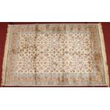 An ivory ground Cashmere rug with an all over floral design under a gold border, 1m 60cm x 2m 30cm.