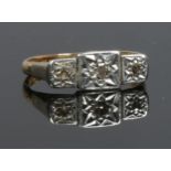 An 18ct gold and platinum three sone diamond ring. Size I.