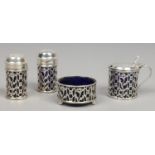 An Edwardian silver four part cruet set with Bristol blue glass liners, assayed Birmingham 1905 etc.