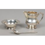 A sterling silver cream jug and small bowl and a white metal spoon, jug and bowl 84 grams.