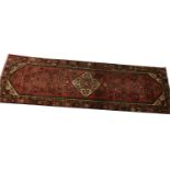 A washed red ground Persian Hamadan runner 320 x 100.1cm.