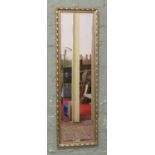 A full length gilt framed bevel edge wall mirror.