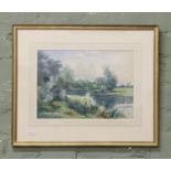 Gilt framed watercolour, rural river landscape with buildings in the distance.