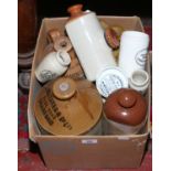 A collection of stoneware to include advertising examples flagons, bed warmers and pot lids etc.