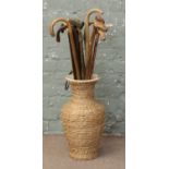 A bundle of walking sticks in pottery and seagrass stickstands. Condition Report.