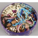 A tin of modern costume jewellery.