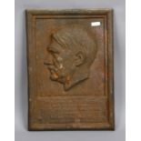 A Third Reich cast iron plaque decorative in relief with a profile portrait of Adolf Hitler and with