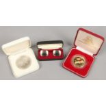 Two cased commemorative coins and a pair of Flying Scotsman cufflinks.