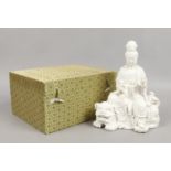 A boxed Chinese de hua blanc de chine figure of Guanyin holding a ruyi sceptre and seated upon the