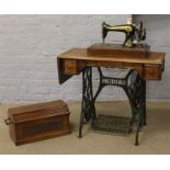 A treadle Singer sewing machine with sewing accessories.