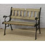 A cast iron two seat garden bench with oak slats.