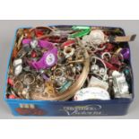 A tin of modern costume jewellery to include brooches, rings, bangles etc.