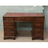 A mahogany twin pedestal desk with inset red leather top.