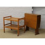 A teak drop leaf table along with a teak tea trolley.