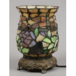 A Tiffany style tablelamp with leaded coloured glass shade, raised on brass effect base.