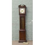 A modern mahogany granddaughter clock with pendulum and weights.