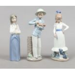 Three Nao porcelain figures one of a boy in hat holding a puppy, one of a girl with a puppy at her