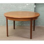 A circular retro teak table with extra leaf within, raised on tapering square supports, along with