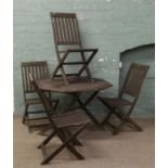 A wooden octagonal garden table and four folding chairs.