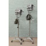 A pair of 1950s theatre stage focusing spot lights, rasied on adjustable bases.