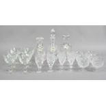 Three cut glass decanters with spirit labels along with three suites of six drinking glasses.