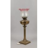 A tablelamp formed as an oil lamp with reeded column and coloured glass shade.