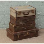 Four vintage suitcases including a leather bound example and one with original paper labels.