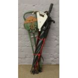 A bundle of walking sticks, litter picker, umbrella and shooting sticks.