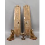 A pair of ornate brass book stands along with a pair of decorative door finger plates and an antique