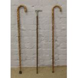 Two walking sticks and a walking cane fitted with a whistle handle.