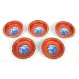 Five 20th century Chinese dishes with scalloped rims. Ground in rouge de fer, gilded and each