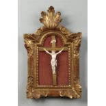 A 19th century Continental carved ivory Corpus Christi on a giltwood cross and mounted within an