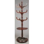 A Regency mahogany bow fronted hat and coat stand. With turned centre column and scrolling pegs,