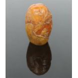 A Chinese carved soapstone boulder desk seal. Decorated in relief with a continuing landscape