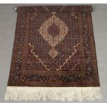 An Afghan hand woven silk and wool carpet. Claret ground and with a Tabriz pattern, 257cm x 143cm.