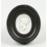 An early 19th century oval glass paste portrait miniature after William Tassie in moulded ebonized