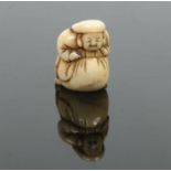 A Japanese Meiji period carved ivory netsuke. Formed as a man leaning upon a large sack, 3.75cm.