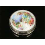 An imported silver pill box with hinged cover enamelled with a garden landscape. Import hallmarks