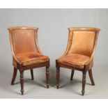 A pair of Regency mahogany leather upholstered library chairs. With concave backrests and raised