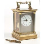 A brass cased carriage clock by Matthew Norman, London. With silvered fluted column supports and