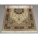 A Persian Kashmir cream ground carpet. With a central medallion under a floral banded border, 1m